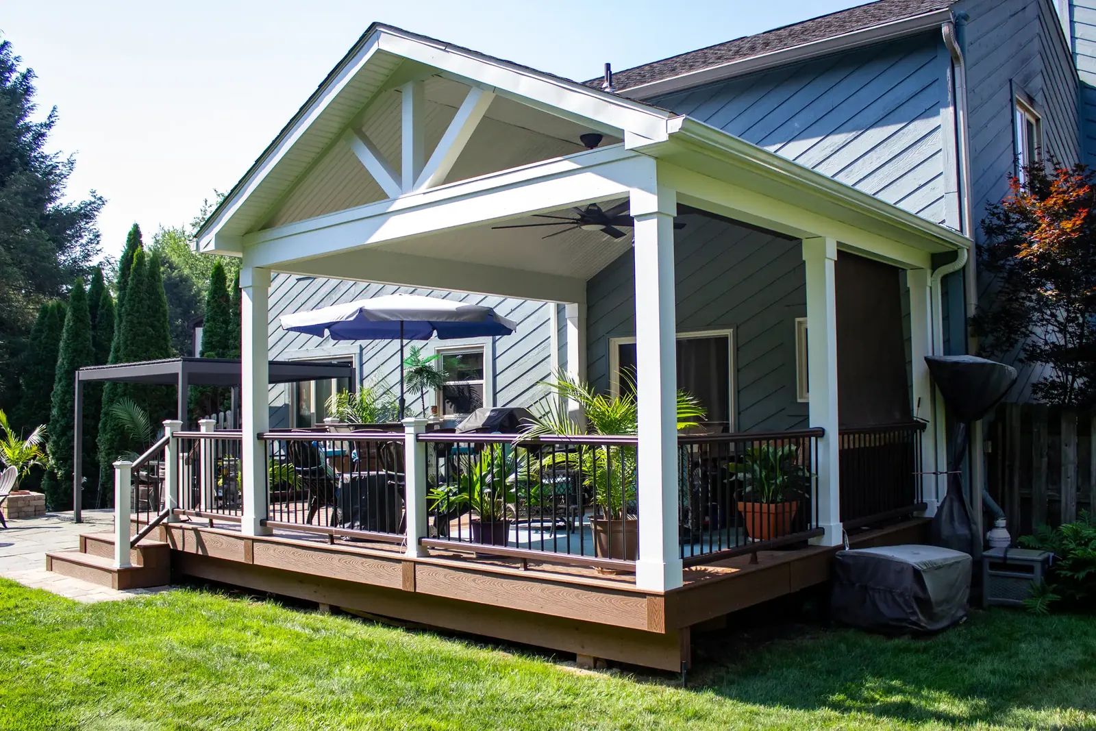 A covered composite deck with white columns built by Oasis Custom Decks in Butler County, Pennsylvania